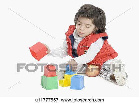 Stock Photo - Boy playing with plastic blocks. Fotosearch