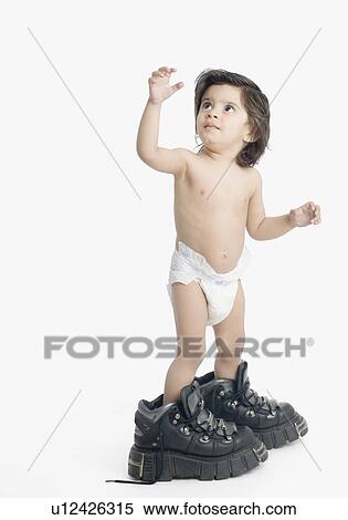 Stock Photography - Boy wearing oversized hiking boots. Fotosearch