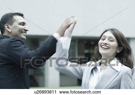 Businessman and a businesswoman giving high-five View Large Photo Image Stock Image - Businessman and a businesswoman giving high-five. Fotosearch