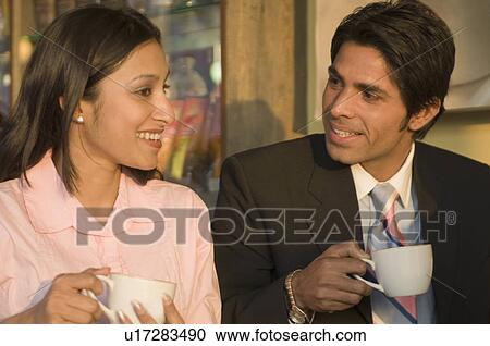 Businessman and a businesswoman holding coffee cups and smiling View Large Photo Image Stock Image - Businessman and a businesswoman holding coffee cups and smiling. Fotosearch