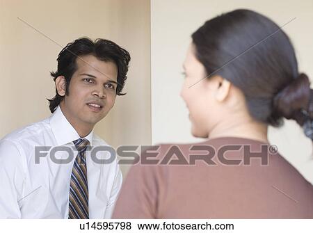 Businessman and a businesswoman talking to each other View Large Photo Image Stock Photo - Businessman and a businesswoman talking to each other. Fotosearch