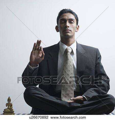 Businessman meditating beside a Buddha statue View Large Photo Image Stock Image - Businessman meditating beside a Buddha statue. Fotosearch