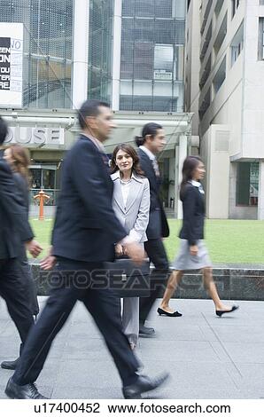 Stock Image - Businessmen and businesswomen walking on the road. Fotosearch