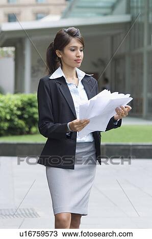 Stock Image - Businesswoman carrying documents. Fotosearch