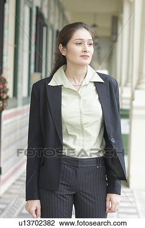 Businesswoman standing in the corridor of a building View Large Photo Image Stock Image - Businesswoman standing in the corridor of a building. Fotosearch