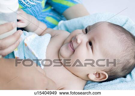 Stock Photo - Close-up of a baby girl lying in her mother's lap. Fotosearch
