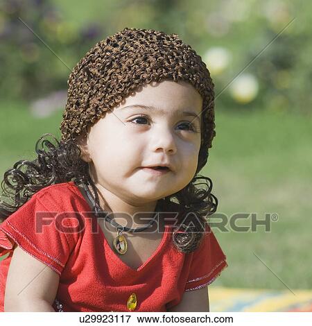 Stock Photo - Close-up of a baby girl wearing a knit hat. Fotosearch