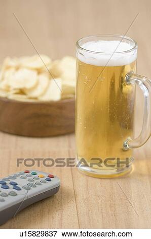 Close-up of a beer glass and a remote control View Large Photo Image Stock Photo - Close-up of a beer glass and a remote control. Fotosearch
