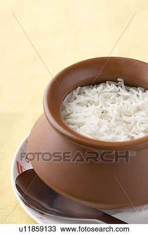 Stock Image - Close-up of a bowl of boiled rice with a spoon on a plate. Fotosearch