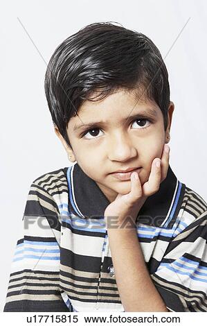 Stock Photography - Close-up of a boy contemplating with his hand on his chin. Fotosearch