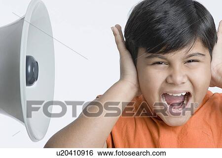 Close-up of a boy covering his ears with his hands View Large Photo Image Stock Photograph - Close-up of a boy covering his ears with his hands. Fotosearch