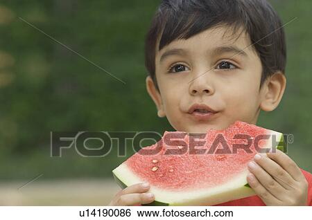 Close-up of a boy holding a slice of watermelon View Large Photo Image Stock Photograph - Close-up of a boy holding a slice of watermelon. Fotosearch