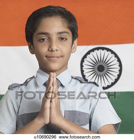Stock Photograph - Close-up of a boy in a prayer position in front of the Indian flag. Fotosearch