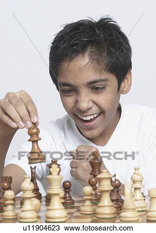 Stock Image - Close-up of a boy playing chess. Fotosearch