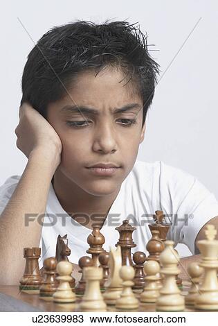 Stock Image - Close-up of a boy playing chess. Fotosearch