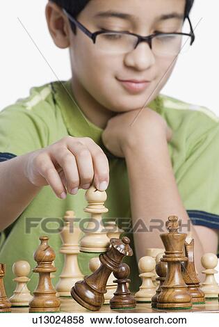 Stock Photo - Close-up of a boy playing chess. Fotosearch