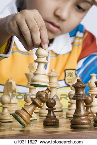 Stock Photo - Close-up of a boy playing chess. Fotosearch