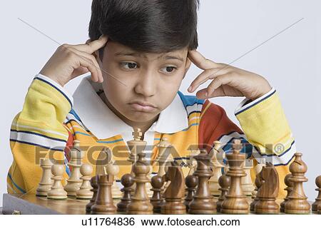 Stock Photograph - Close-up of a boy playing chess. Fotosearch