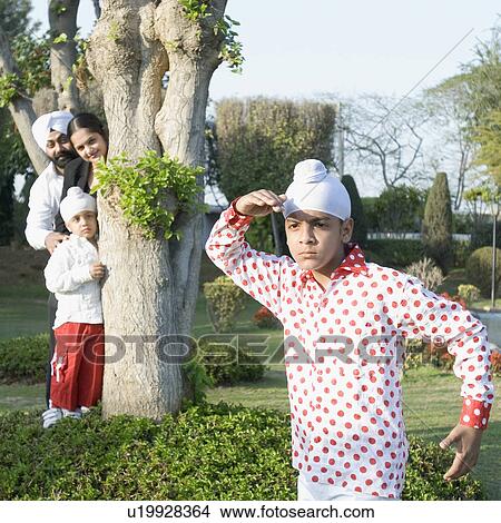 Close-up of a boy playing hide and seek with his brother and parents View Large Photo Image Picture - Close-up of a boy playing hide and seek with his brother and parents. Fotosearch