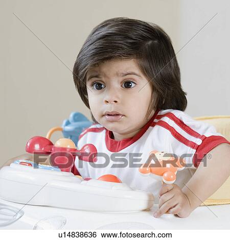 Stock Photograph - Close-up of a boy sitting in a baby walker. Fotosearch