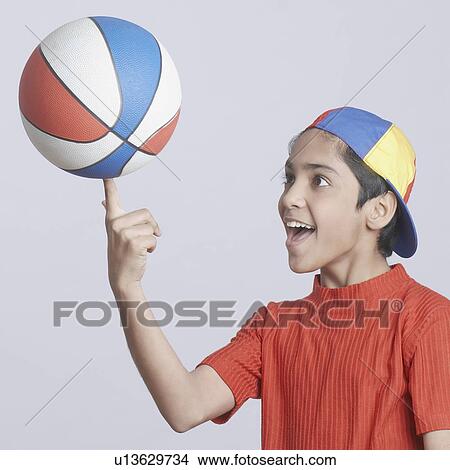 Picture - Close-up of a boy spinning a basketball on his finger. Fotosearch