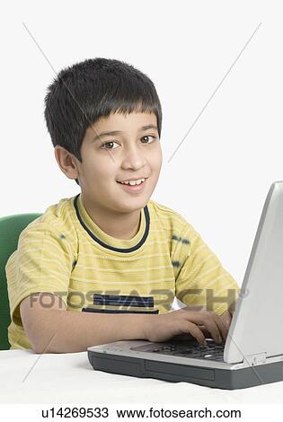 Stock Image - Close-up of a boy using a laptop. Fotosearch