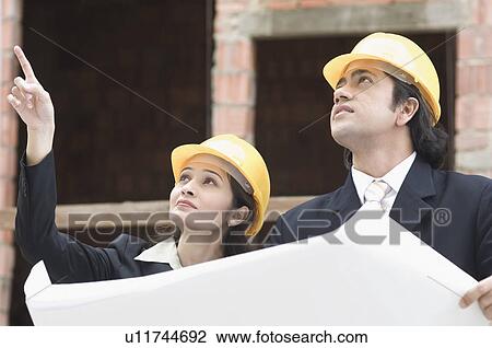Close-up of a businessman and a businesswoman at a construction site View Large Photo Image Stock Image - Close-up of a businessman and a businesswoman at a construction site. Fotosearch