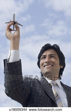 Close-up of a businessman holding a model airplane View Large Photo Image Picture - Close-up of a businessman holding a model airplane. Fotosearch