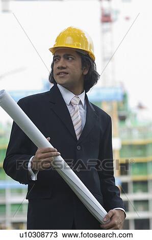 Stock Image - Close-up of a businessman holding a blueprint. Fotosearch