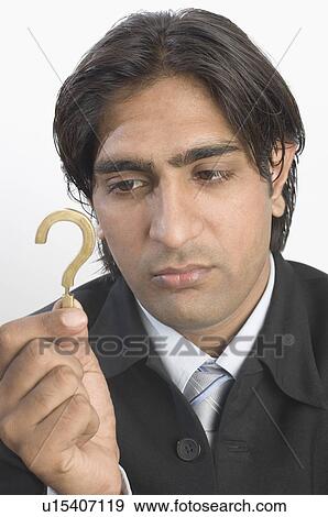 Close-up of a businessman holding a question mark sign View Large Photo Image Stock Photo - Close-up of a businessman holding a question mark sign. Fotosearch