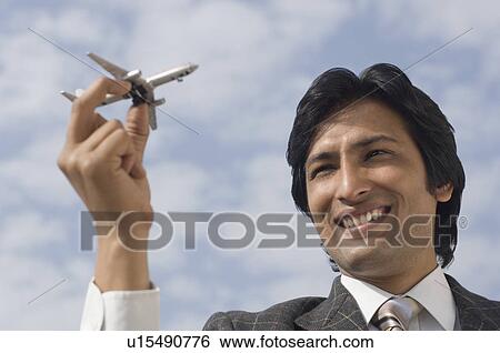 Close-up of a businessman holding a model airplane View Large Photo Image Stock Photograph - Close-up of a businessman holding a model airplane. Fotosearch