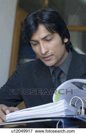 Close-up of a businessman looking at a file View Large Photo Image Stock Photo - Close-up of a businessman looking at a file. Fotosearch