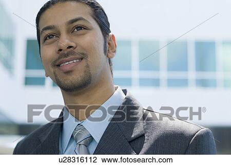 Close-up of a businessman smiling View Large Photo Image Stock Image - Close-up of a businessman smiling. Fotosearch