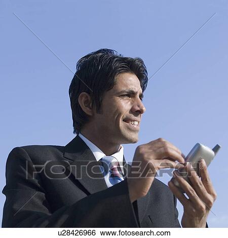 Close-up of a businessman using a personal data assistant View Large Photo Image Stock Photograph - Close-up of a businessman using a personal data assistant. Fotosearch