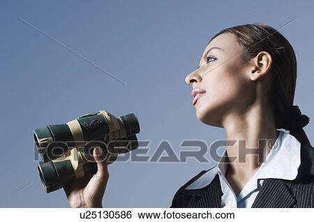 Stock Photograph - Close-up of a businesswoman holding a pair of binoculars. Fotosearch