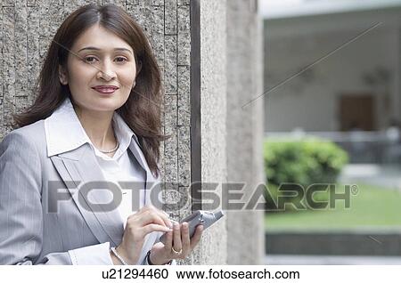 Close-up of a businesswoman operating a mobile phone View Large Photo Image Stock Image - Close-up of a businesswoman operating a mobile phone. Fotosearch