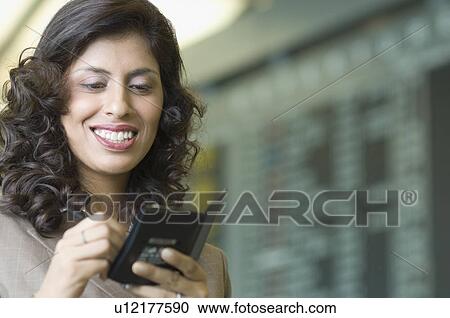 Stock Image - Close-up of a businesswoman writing on a passport. Fotosearch