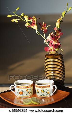 Stock Photography - Close-up of a flower vase and two cups of tea. Fotosearch