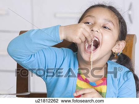 Stock Image - Close-up of a girl eating noodles. Fotosearch