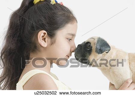 Stock Image - Close-up of a girl playing with her dog. Fotosearch
