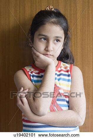 Stock Image - Close-up of a girl with her hand on her chin. Fotosearch