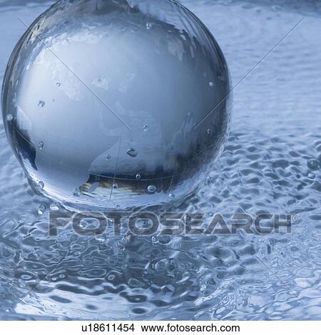 Picture - Close-up of a globe on the surface of water. Fotosearch