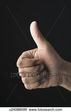 Stock Photo - Close-up of a man's hand showing thumbs up sign. Fotosearch