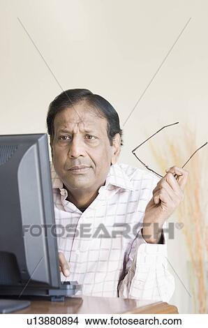 Close-up of a mature man working on a computer View Large Photo Image Picture - Close-up of a mature man working on a computer. Fotosearch