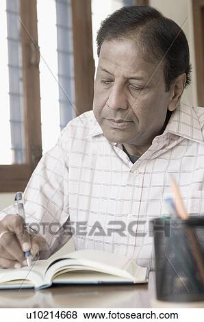 Close-up of a mature man writing in a diary View Large Photo Image Stock Photo - Close-up of a mature man writing in a diary. Fotosearch