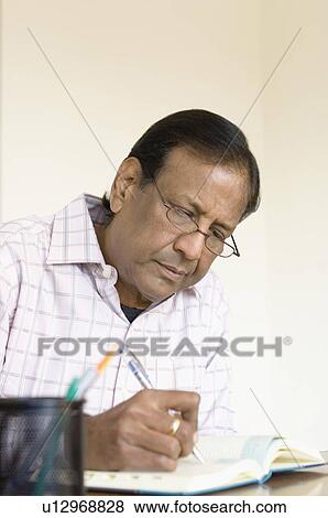 Close-up of a mature man writing in a diary View Large Photo Image Stock Photo - Close-up of a mature man writing in a diary. Fotosearch