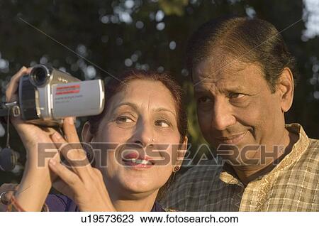 Close-up of a mature woman holding a digital video camera with a mature man smiling beside her View Large Photo Image Stock Image - Close-up of a mature woman holding a digital video camera with a mature man smiling beside her. Fotosearch