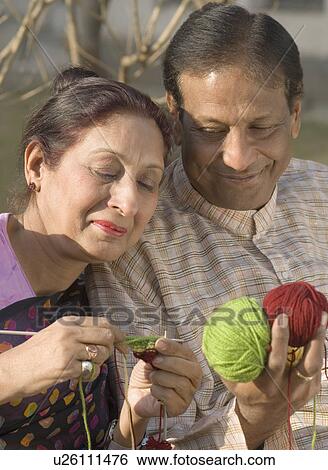 Stock Photograph - Close-up of a mature woman knitting with a mature man. Fotosearch