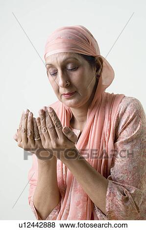 Close-up of a mature woman praying View Large Photo Image Stock Photo - Close-up of a mature woman praying. Fotosearch