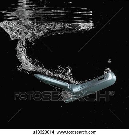 Picture - Close-up of a mobile phone underwater. Fotosearch